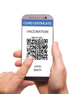 man's hand holding a phone with a vaccination code on the screen