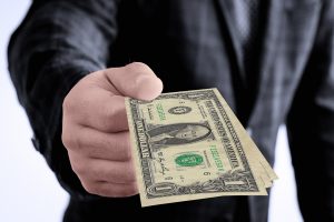 man's torso in a suit with money in his hand