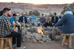 people sitting at a campfire laughing