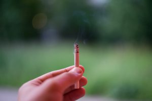 person's hand holding up a cigarette