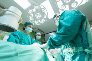 doctors and nurses in scrubs in an operating room with someone on the table