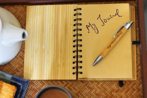 an open book with the words "my journal" written in it and a pen laying on the page.