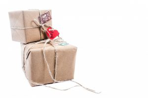 two boxes wrapped with string and a heart tag