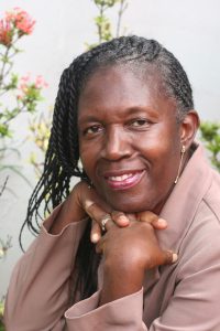 older african american woman smiling with her hands under her chin