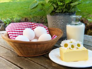 eggs in a basket, cheese, milk, and greens in a pot