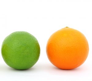 a green lime next to an orange