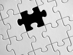 white puzzle with a piece missing that is in black