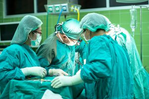 doctors in teal scrubs performing surgery