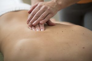 person laying down with no shirt on getting a massage