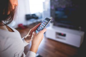 person looking at their phone with apps on the screen
