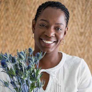African American woman holding thistle smiling