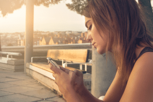 woman looking at her phone with a sad look on her face