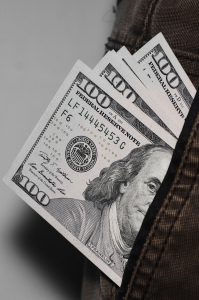 hundred dollar bills sticking out of a pocket
