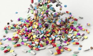 hundreds of colorful pills falling on top of each other