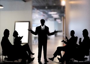 silhouette of a man standing in the middle of a meeting 