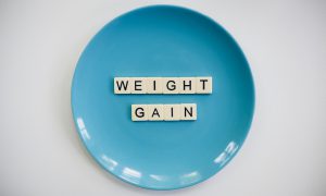 blue plate with letters spelling out weight gain in the middle 
