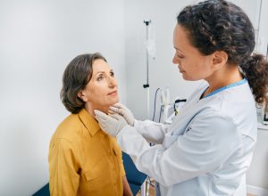 female doctor checking an older woman's throat