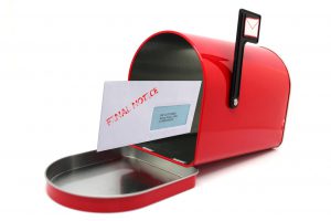 evelope with the words final notice on it coming out of a red mailbox