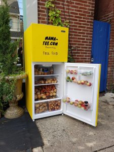 yellow fridge on the sidewalk that is open and filled with fruits and vegetables
