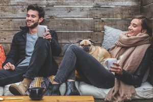 a man and woman sitting down with coffee laughing