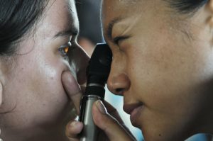 woman looking into the ye of another woman with light