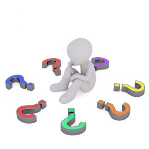 silhouette of a person sitting down with different colored question marks all around in a circle