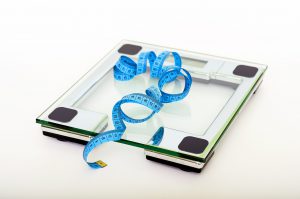 scale with a blue measuring tape on top of it