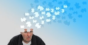 older man with his head dispersing as puzzle pieces