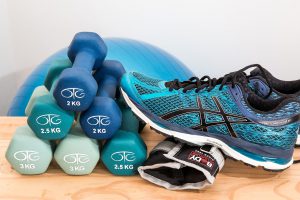 teal asics sneaker next to a pile of little dumbbells