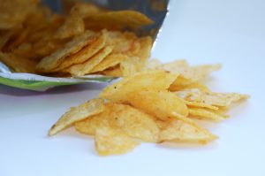 bag of chips open and some on a table