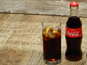 bottle of coke next to a glass filled with coke