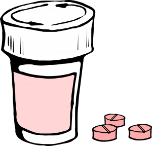 pink pills next to a bottle of medicine