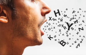 man's mouth open with letters coming out of it