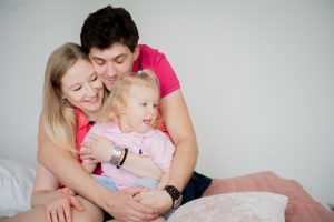man hugginf a woman and child on her lap