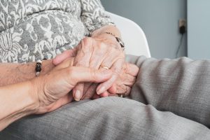 older person's hands holding another person's hand