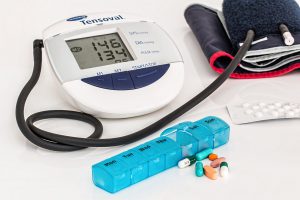 blood pressure machine with high numbers and medicine next to it
