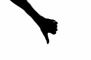 silhouette of a hand with the thumbs down
