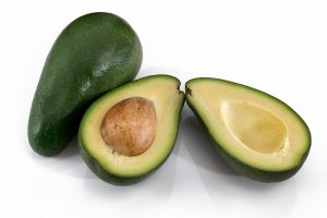 avocados, one cut open in half