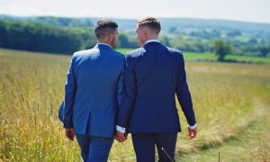 2 men in suits holding hands