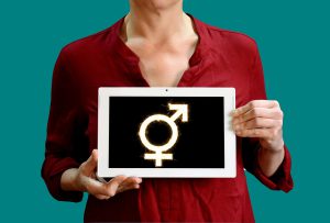 woman holding a sign with transgender symbol