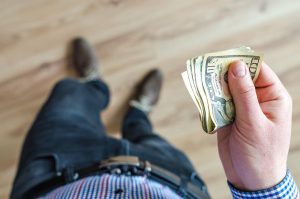 a man holding cash in his hand
