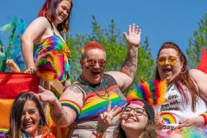 people in rainbow clothing smiling