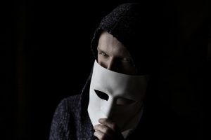 man holding a white mask close to his face