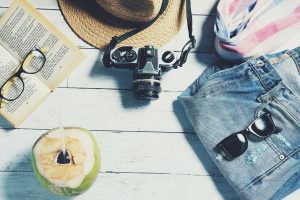 hat, camera, a book and sunglasses