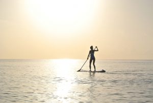 woman standing on a paddleboard in the ocean 