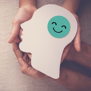 cutout of a head with a smiley face where the brain is