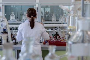 woman in a lab coat looking at viales