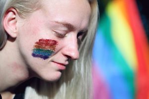 caucasian with a rainbow flag painted on their face