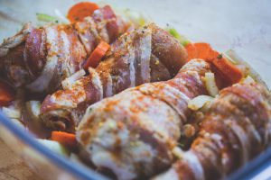raw chicken drums with spices and vegetables around it