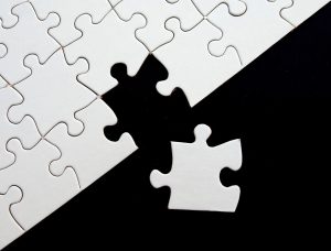 white puzzle with missing piece next to it